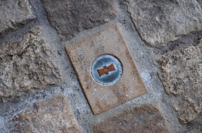 Ein Stein im Pfleaster unter dem Ratssaal markiert den Mittelpunkt der Stadt.